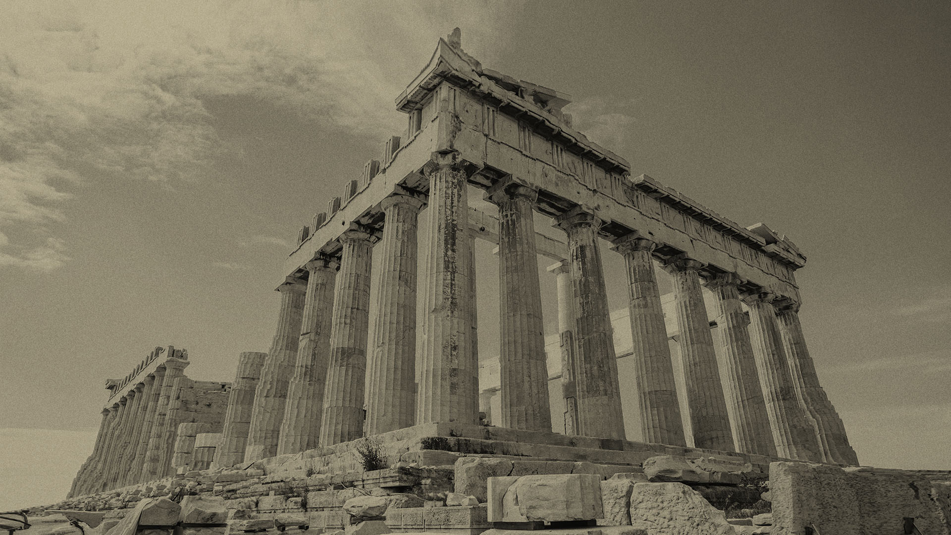 Das antike Parthenon in Athen, Griechenland, mit seinen markanten dorischen Säulen und teils beschädigtem Dach, aufgenommen aus der Froschperspektive bei Tageslicht.