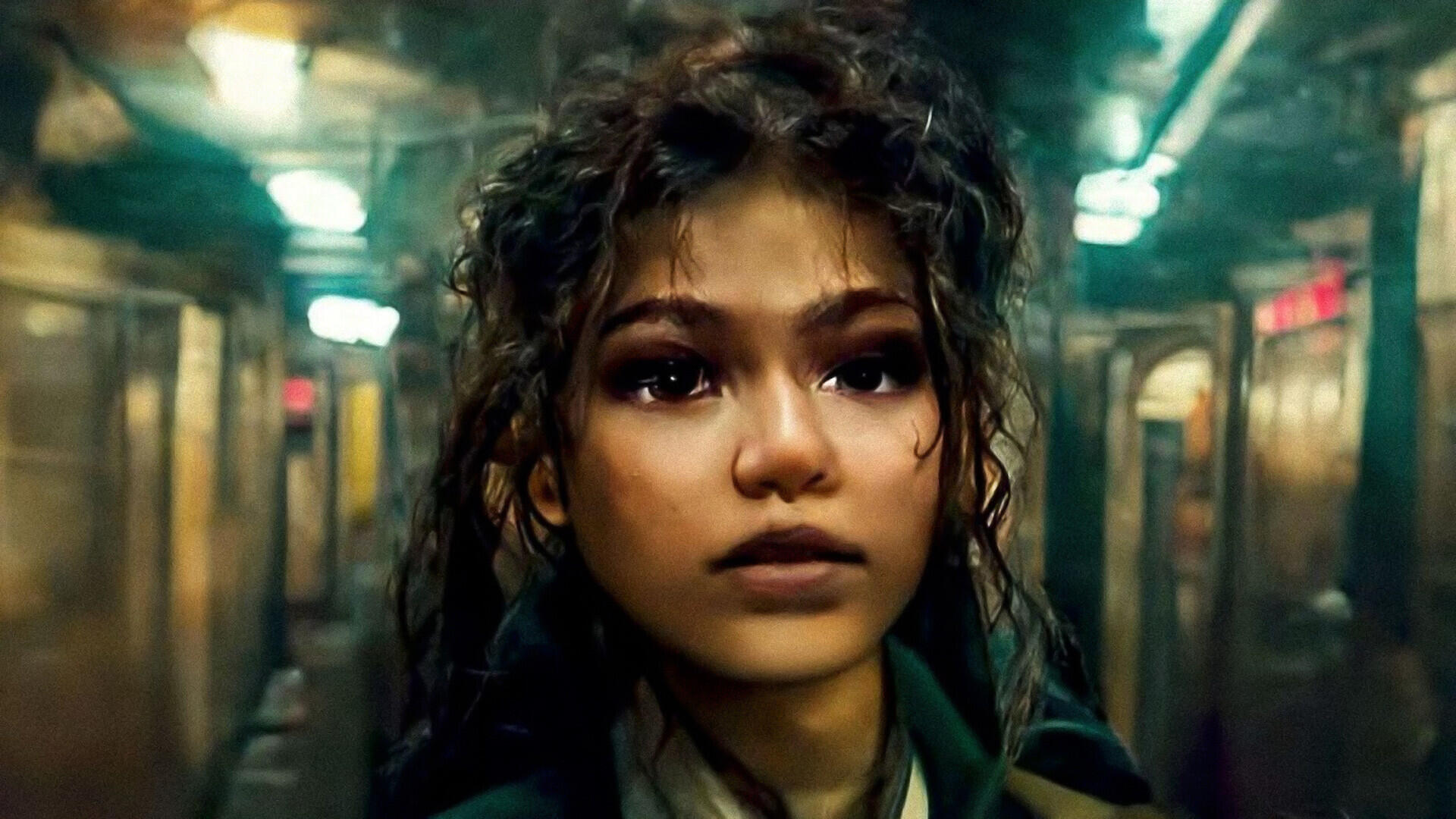 Person mit lockigen Haaren steht in einem alten, beleuchteten U-Bahn-Waggon und blickt nach vorne.